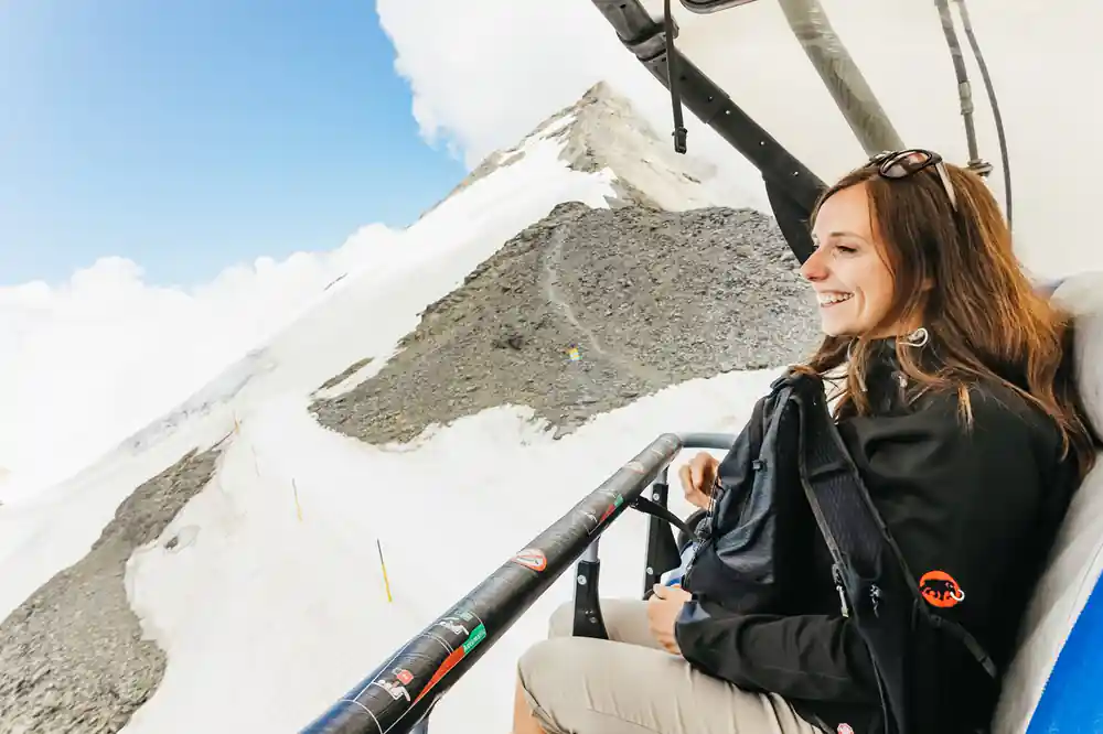 A passenger riding the Ice Flyer chair above the snow