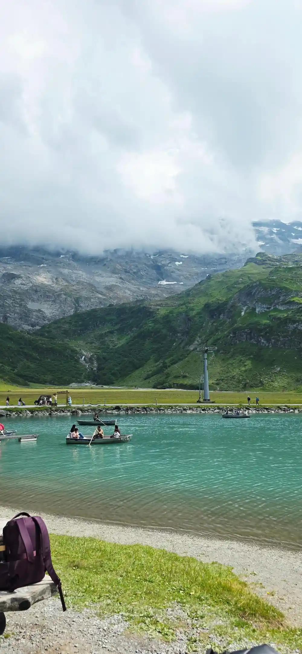 Rowing boats on the green water of Trubsee under the ridge
