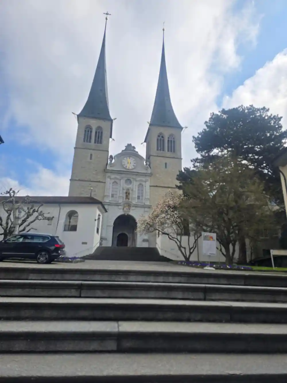 The twin spires of the Hofkirche above a Lucerne square