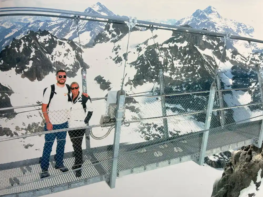 Two visitors posing on the Cliff Walk with the peaks behind