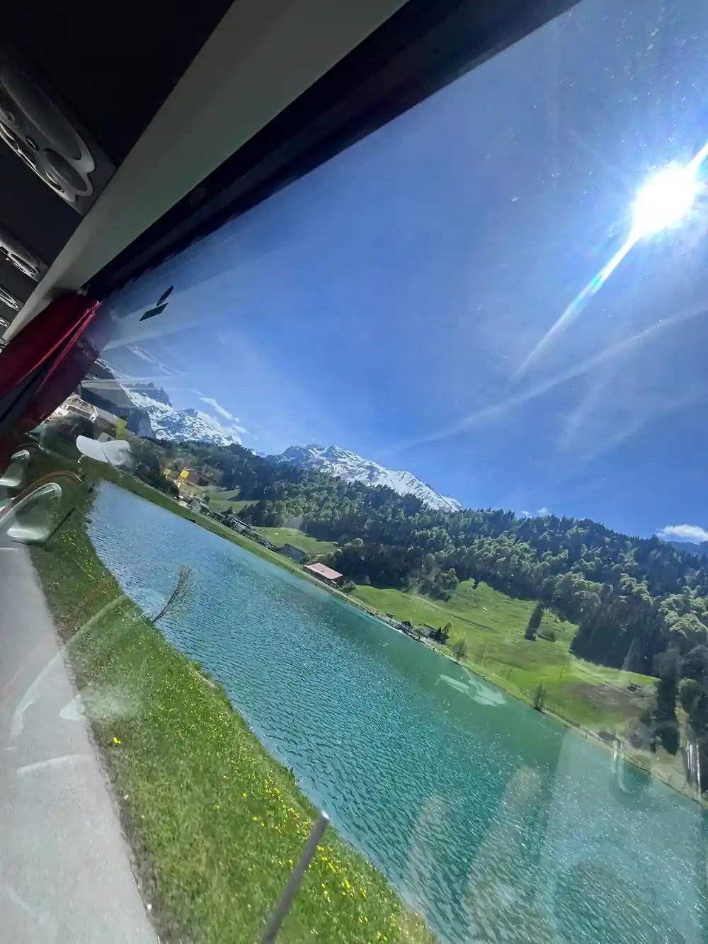 The valley through the curved window of a descending cabin