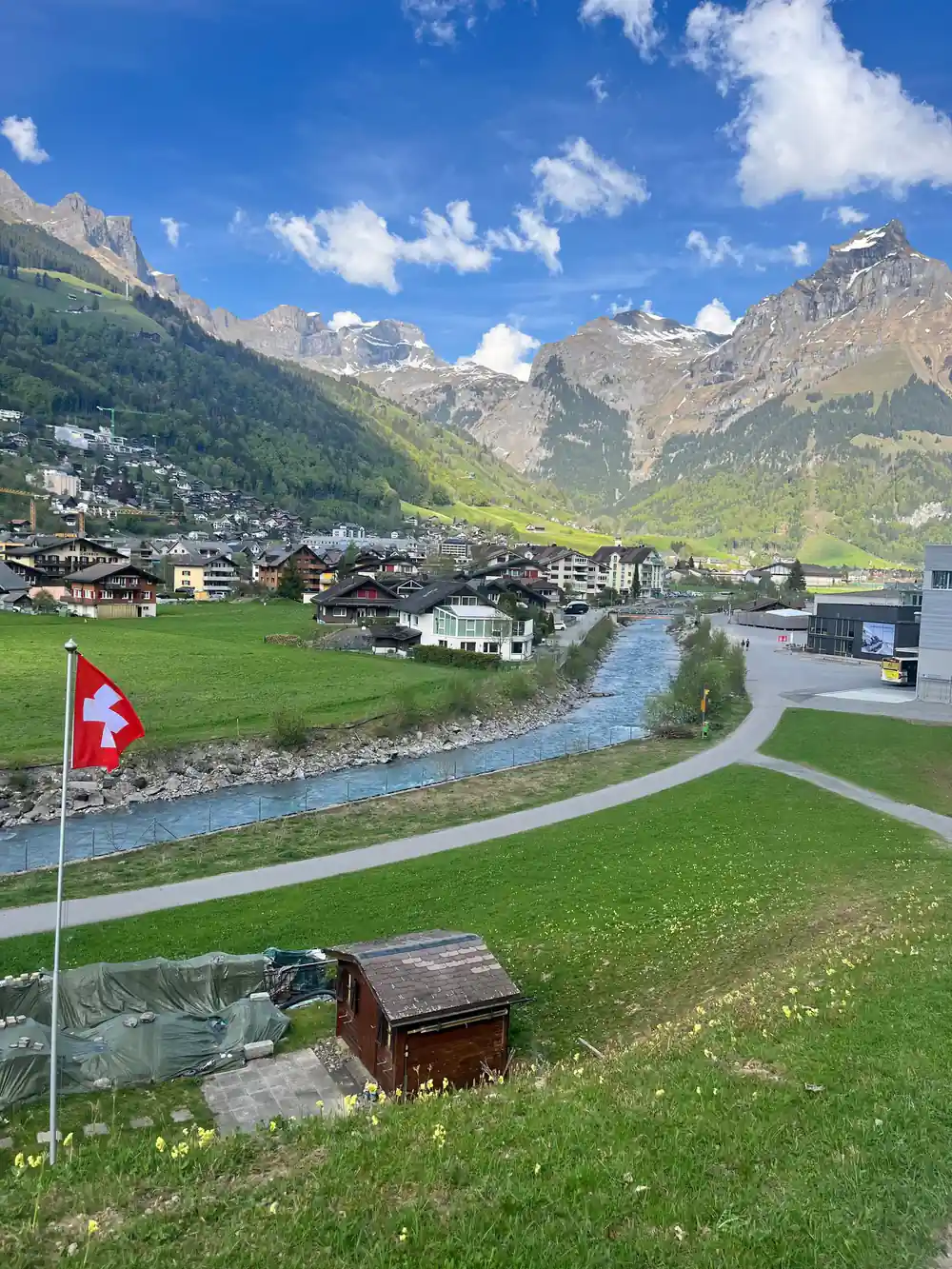 The village of Engelberg in its green valley with a Swiss flag