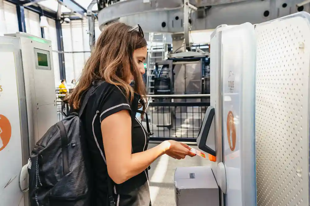A visitor scanning a ticket at the station barrier