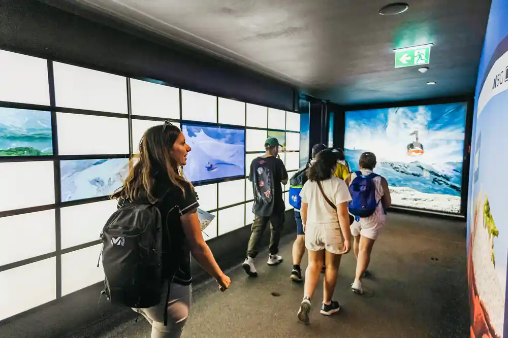 Visitors walking through the cable car station past lit panels